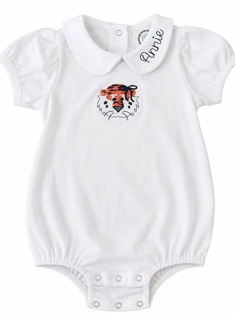 A white baby bubble romper with a Peter Pan collar, an embroidered Auburn tiger, and the name Annie stitched in navy script